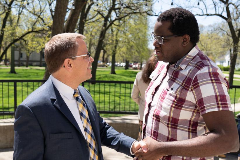 President Eric Boynton shakes hands with a fellow colleague.